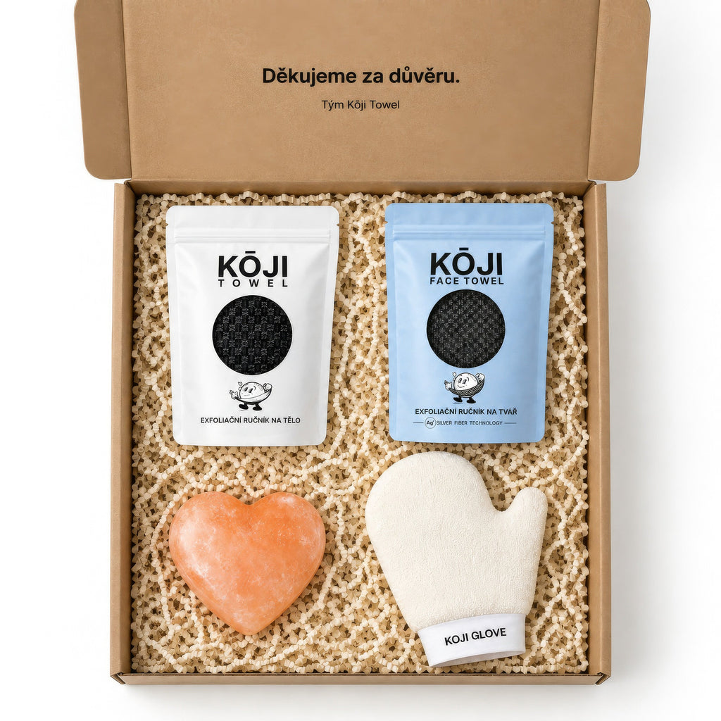 Pohľad zhora do otvorenej krabice Kōji — štyri produkty súpravy rozložené v papierovej výplni.